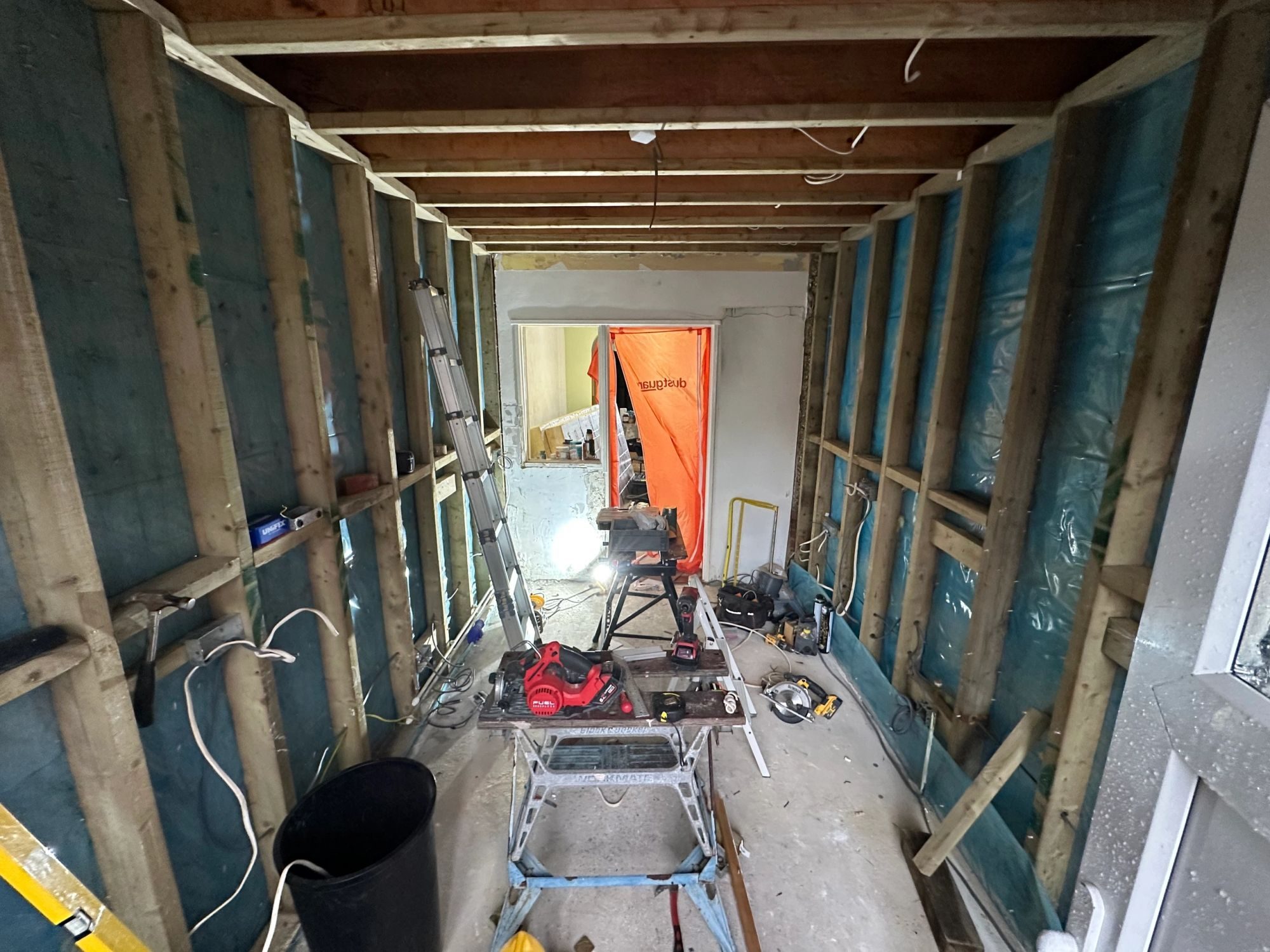New stud partitions with a vapour barrier and timber framing, cables run ready for boarding.